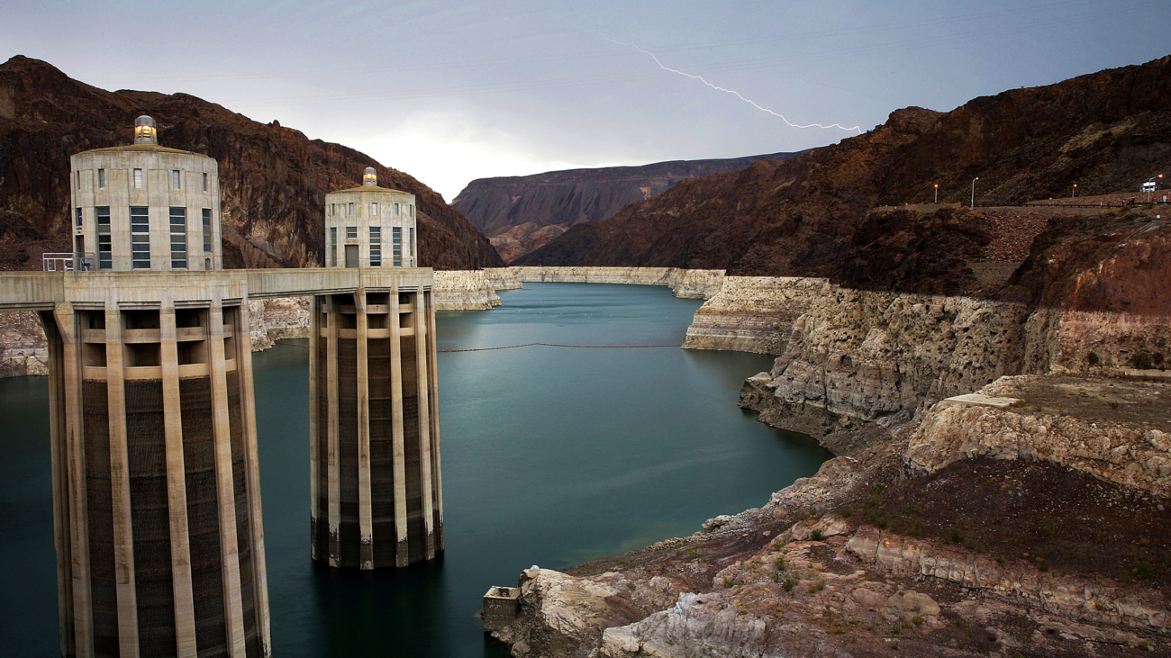 FILE - In this July 28, 2014, file photo, lightning strikes over Lake Mead near Hoover Dam that impounds Colorado River water at the Lake Mead National Recreation Area in Arizona.  The Bureau of Reclamation is forecasting first-ever water shortages because of falling levels at Lake Mead and says the reservoir could drop so low that it might not be able to generate electricity at Hoover Dam. (AP Photo/John Locher, File)